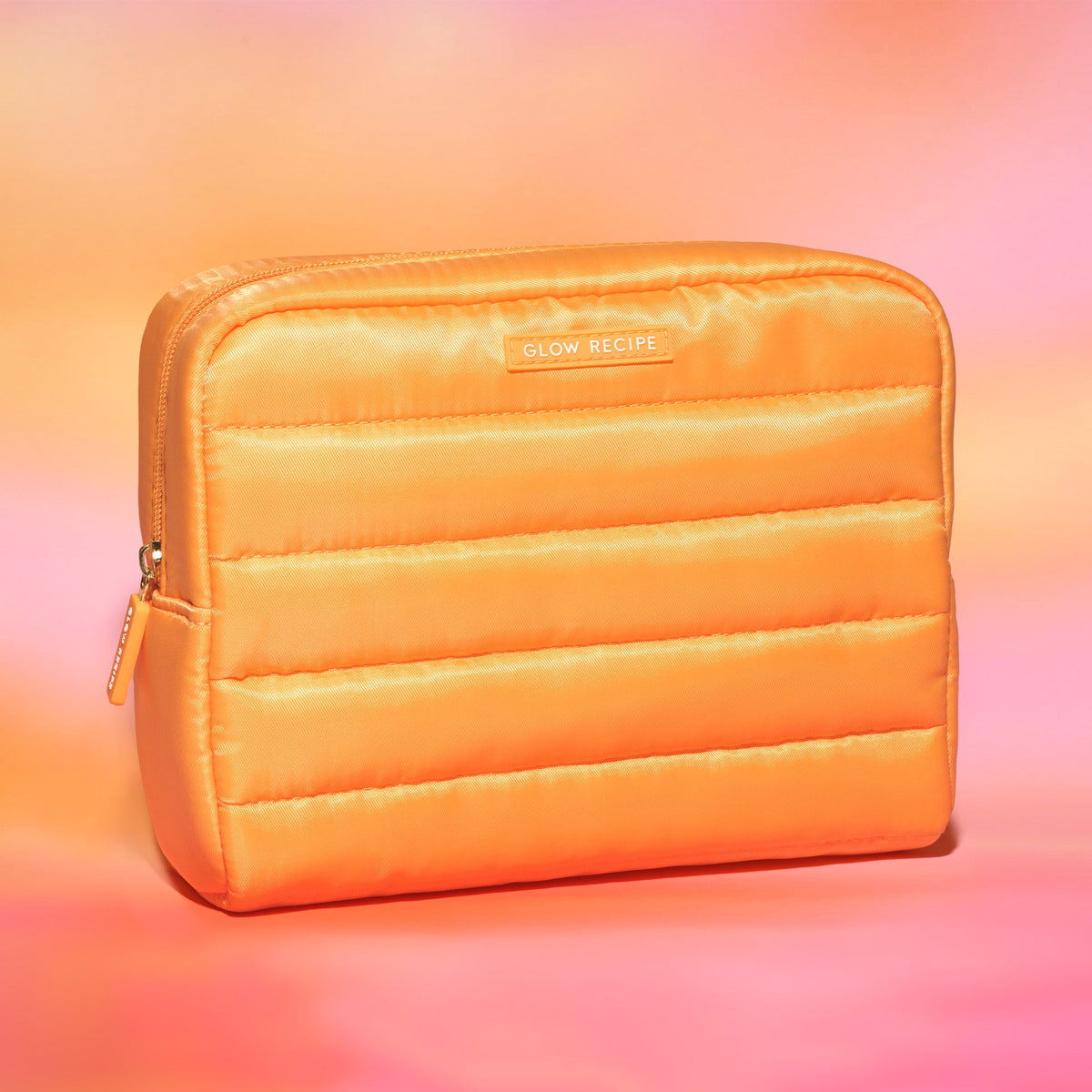 Orange quilted pouch with 'Glow Recipe' branding on a gradient background