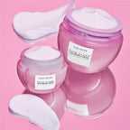 Two Mini Size (20ml) jars of Glow Recipe Plum Plump Hyaluronic Cream displayed side by side on a soft pink background.