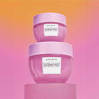 Mini Size (20ml) Plum Plump Hyaluronic Cream jars stacked on top of each other against an orange-to-pink gradient backdrop.